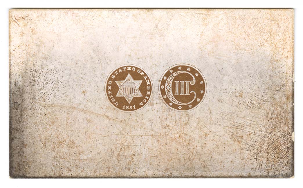 Die trial on card of circles containing a six-pointed star and a roman numeral three with a large C surrounded by stars.