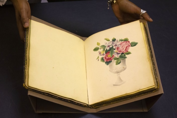 Jasmine Smith, LCP African American history subject specialist, holds a rare friendship album. Jasmine Smith, LCP African American history subject specialist, holds a rare friendship album.