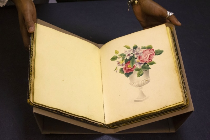 Jasmine Smith, LCP African American history subject specialist, holds a rare friendship album.