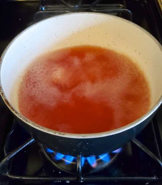 Preparing the pickling bring by boiling water with vinegar, salt, and pickling spices