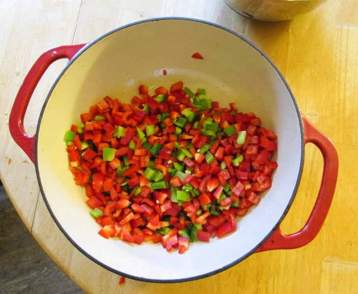Minced red and green peppers in an cast iron enamel pot