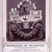 Photograph advertisement of different sized sponges arranged in a garland decorating a table filled with boxes and bottles.