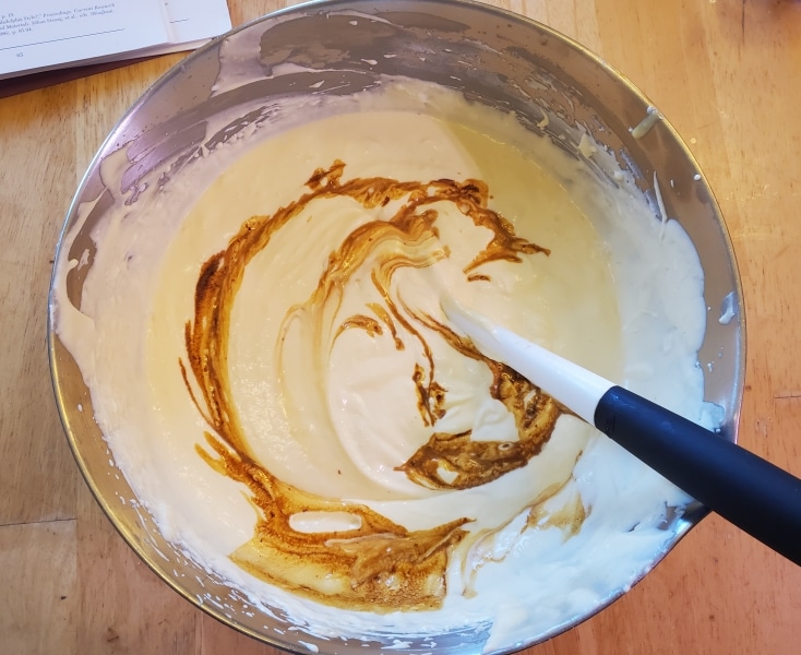 Adding the strained caramel "tea" the egg cream batter Adding the strained caramel "tea" the egg cream batter