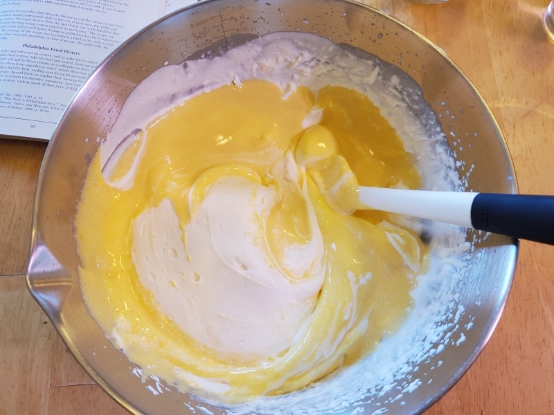 Folding the eggs and sugar into the whipped cream Folding the eggs and sugar into the whipped cream