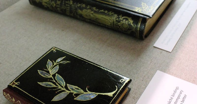 Two examples of papier-mâché bindings laid out in an exhibition case, 2010. Jennifer Rosner, Chief of Conservation.