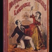 White woman in gown with knife standing over kneeling white man with goatee and in suit.